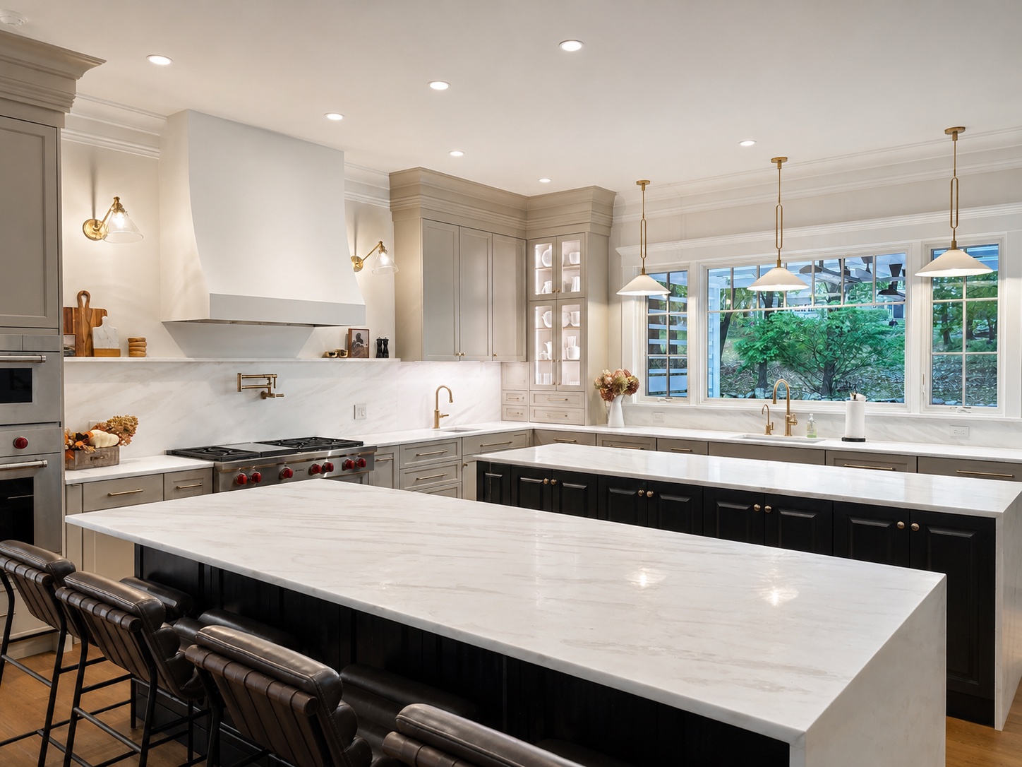 Modern kitchen island painting with black island cabinetry, white marble counters, and pendant lights